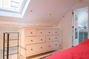 a bedroom with a dresser and a window at La Garçonnière de Wiertz - Esc'Appart in Dinant
