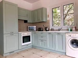 a kitchen with white cabinets and a washing machine at Villa Sikia in Katokhórion