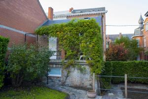 a brick house with ivy on the side of it at La Garçonnière de Wiertz - Esc'Appart in Dinant