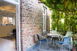 a patio with chairs and a table and a brick wall at La Garçonnière de Wiertz - Esc'Appart in Dinant