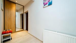 a hallway with a white wall and a mirror at Apartamenty EverySky - Kowary 1 Maja 52-1 in Kowary