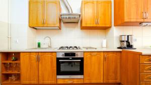 a kitchen with wooden cabinets and a stove top oven at Apartamenty EverySky - Kowary 1 Maja 52-1 in Kowary