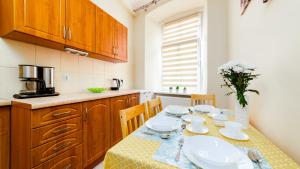een keuken met een tafel en stoelen en een keuken met een tafel en een stoeltje bij Apartamenty EverySky - Kowary 1 Maja 52-1 in Kowary