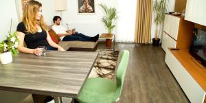 a woman sitting at a table in a living room at Comfort Boardinghouse in Kornwestheim