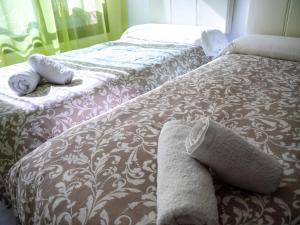 dos camas sentadas una al lado de la otra en un dormitorio en Apartamento S.Quintin, en Málaga