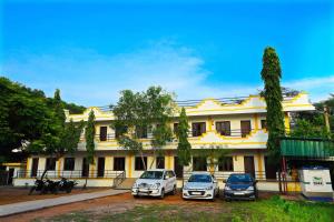 un grupo de coches estacionados frente a un edificio en Rani Residency, en Pondicherry