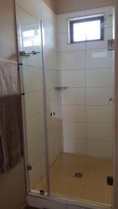 um chuveiro com uma porta de vidro na casa de banho em Esther's Country Lodge em Hekpoort