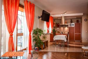 a kitchen with orange curtains and a dining room at Radan in Władysławowo