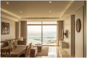 a living room with a dining table and a view of the ocean at View @ The Bay Apartments in Mossel Bay