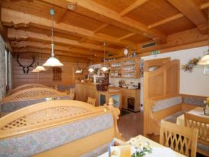 a dining room and kitchen with wooden ceilings at Pension Appartementhaus Bergland in Biberwier