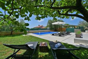 une cour avec une piscine, 2 chaises et une table dans l'établissement Charming villa Natali with private pool in Pula, à Galižana