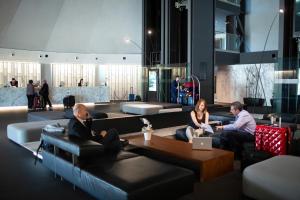 a group of people sitting on couches in a lobby at BAH Barcelona Airport Hotel in El Prat de Llobregat