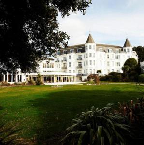 a large white building with a large lawn in front of it at Royal Bath Hotel & Spa Bournemouth in Bournemouth