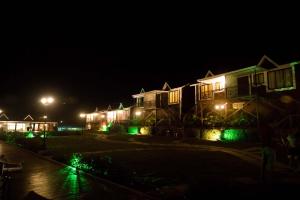 una fila de casas por la noche con luces verdes en Green Velvet Resort-Near Pawna Lake, en Lonavala