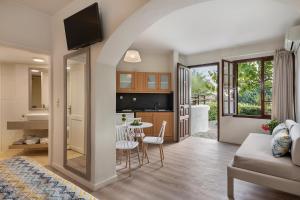 a living room with a couch and a table with chairs at Alianthos Suites in Tersanas