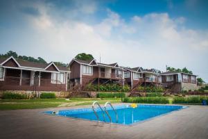 a row of houses with a swimming pool in front at Green Velvet Resort-Near Pawna Lake in Lonavala