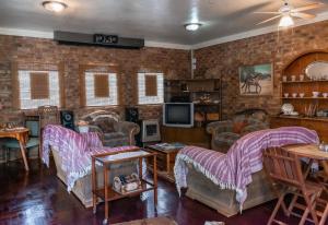 uma sala de estar com sofás e uma televisão em Bastille de Blignaut B&B em Edenvale