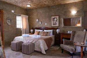 a bedroom with a bed and a desk and a chair at Bastille de Blignaut B&B in Edenvale