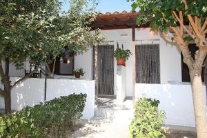 a white house with trees and a fence at Karidies in Skopelos Town