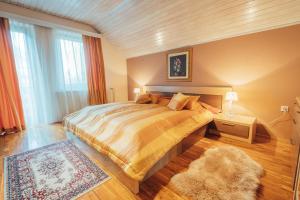 a bedroom with a large bed and a rug at Apartma BOROVC in Mojstrana