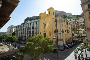 a yellow building with a clock tower on a city street at La Corte dei Borboni by Dimorra in Naples