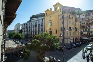 a view of a city street with a yellow building at La Corte dei Borboni by Dimorra in Naples
