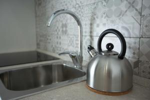 a stainless steel tea kettle sitting next to a kitchen sink at La Corte dei Borboni by Dimorra in Naples