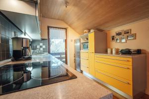 a kitchen with yellow cabinets and a counter top at Apartma BOROVC in Mojstrana