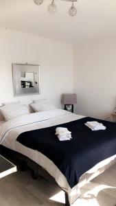 a bedroom with a large bed with two towels on it at Joli Studio A Euroairport-BASEL-MULHOUSE-FREIBURG in Saint-Louis