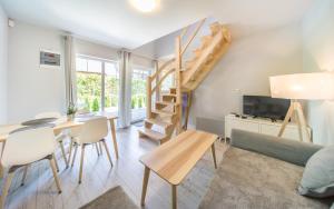 een woonkamer met een trap en een tafel en stoelen bij Domki No.155 in Pobierowo