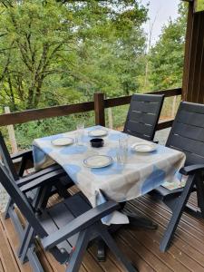 a table with plates and glasses on a deck at Puy Rond Camping in Bressuire