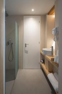 a bathroom with a shower with a glass door at L Anima Boutique Suites in Skiathos Town