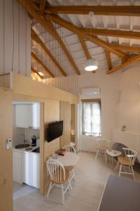 een keuken en een woonkamer met een tafel en stoelen bij L Anima Boutique Suites in Skiathos-stad