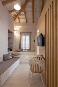 een kamer met een bed, een tafel en een tv bij L Anima Boutique Suites in Skiathos-stad