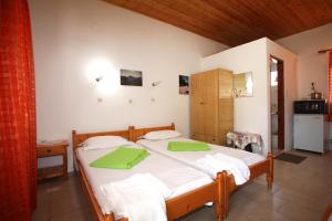 a bedroom with a bed with green towels on it at Karidies in Skopelos Town