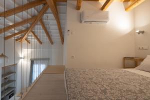 een slaapkamer met witte muren en houten balken bij L Anima Boutique Suites in Skiathos-stad