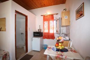 a kitchen with a table with a bowl of fruit on it at Karidies in Skopelos Town +13 photos
