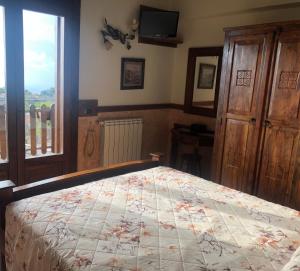 a bedroom with a bed and a television and a window at Agriturismo La Baita in Agerola