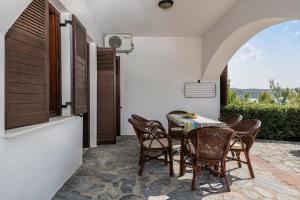 
a dining room table with chairs and a patio at Alianthos Suites in Tersanas
