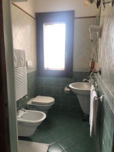 a bathroom with a toilet and a sink and a window at Agriturismo La Baita in Agerola