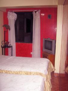 a bedroom with two beds and a television at Hospedaje Pumacurco Betty in Cusco