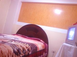 1 dormitorio con 1 cama y TV en Hospedaje Pumacurco Betty, en Cusco