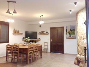 comedor con mesa, sillas y TV en 5 bedrooms house with private pool furnished terrace and wifi at Zambra en Zambra