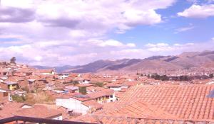 una ciudad con techos rojos y montañas en el fondo en Hospedaje Pumacurco Betty, en Cusco