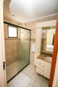 a bathroom with a shower and a sink at Suites Natalia Enseada in Guarujá