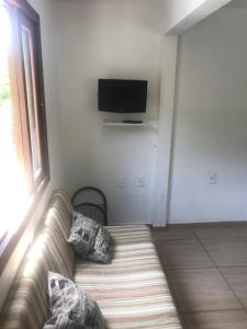 sala de estar con sofá y TV de pantalla plana en Fortaleza Logde, en Florianópolis