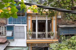 a building with a balcony with blue and yellow at Centraltique Downtown - Bespoke Colonial House Near Hoan Kiem Lake in Hanoi