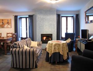 sala de estar con 2 sofás, mesa y chimenea en Casa Rural Urandi I, en Burgui