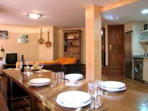 una sala de estar con una mesa con platos y copas de vino en Casa Rural Urandi I, en Burgui