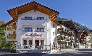 a large white building with a wooden roof at Hotel Salzburgerhof in Flachau